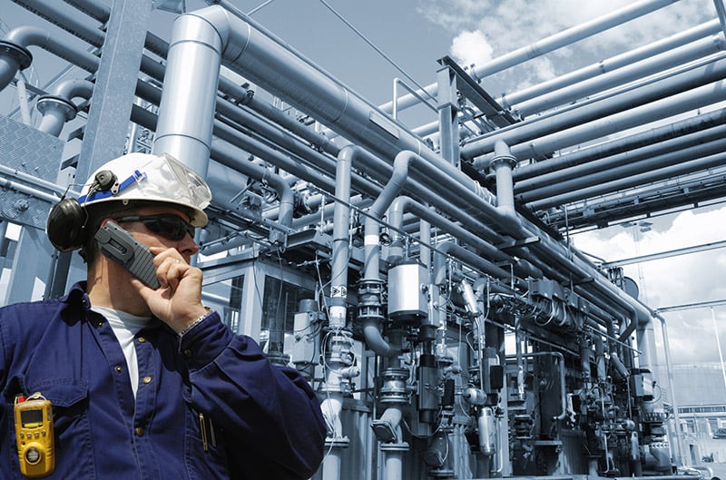 A Swagelok fluid systems engineering and assembly services technician is on the phone at a job site