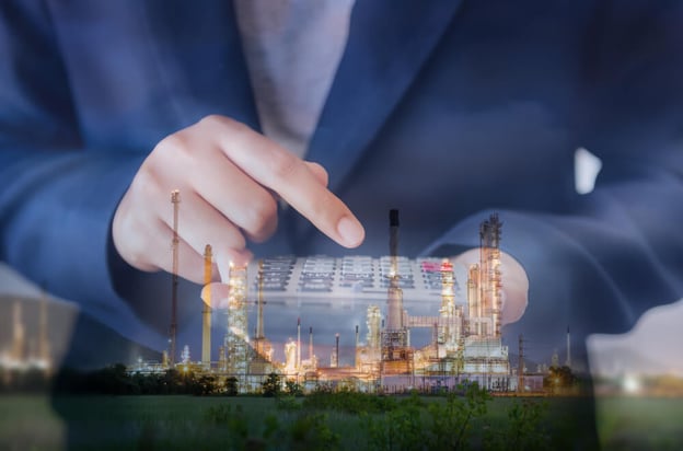 Double exposure of businesswoman using calculator against oilgas refinery plant