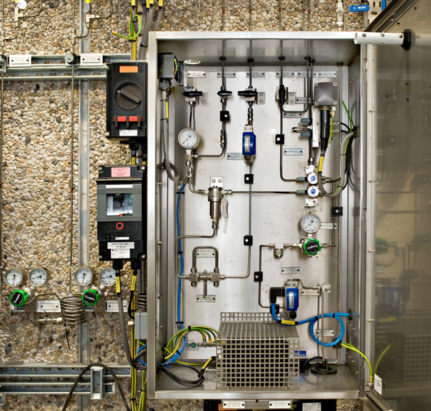 Interior view of a sulfinert coated sample conditioning system featuring SwagelokÂ® stream selector valves, regulators, 40 series ball valves, and filters.
