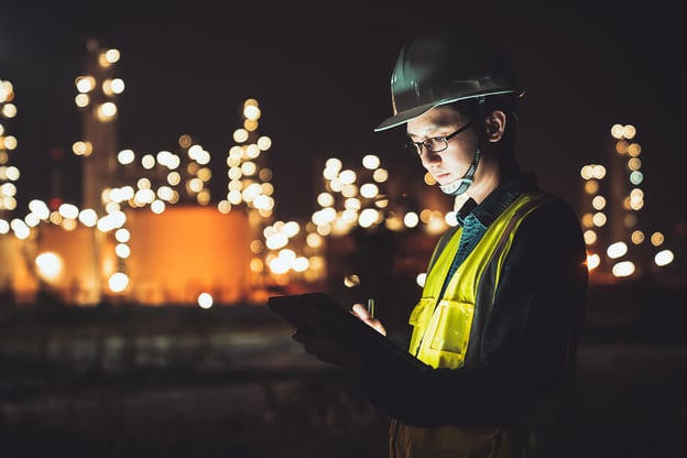 engineer in front of petroleum oil refinery at night