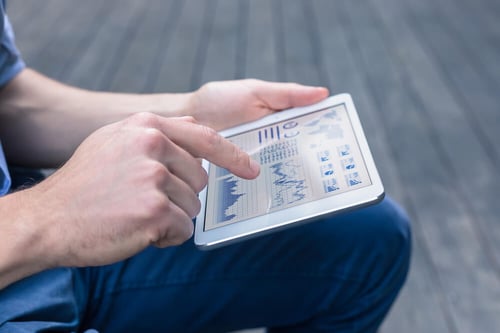 person using tablet to analyze charts and KPIs