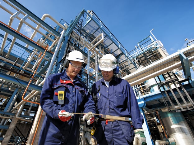 two oil and gas workers with main station at refinery industry